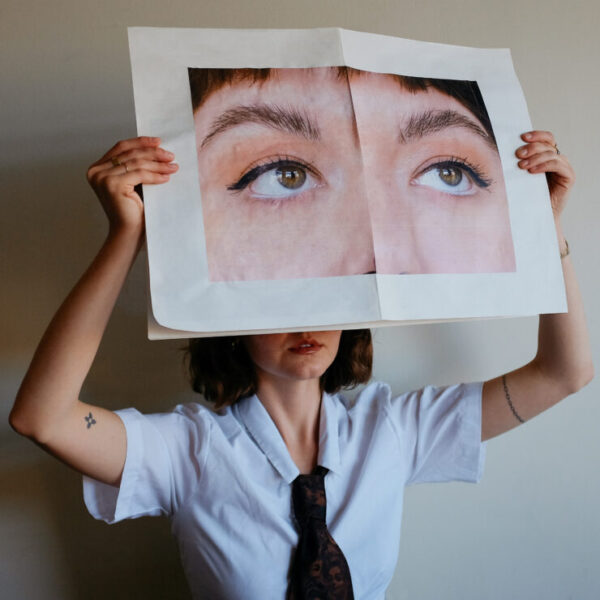Lindsey Evans holds up a huge printout of just her eyes in front of her face