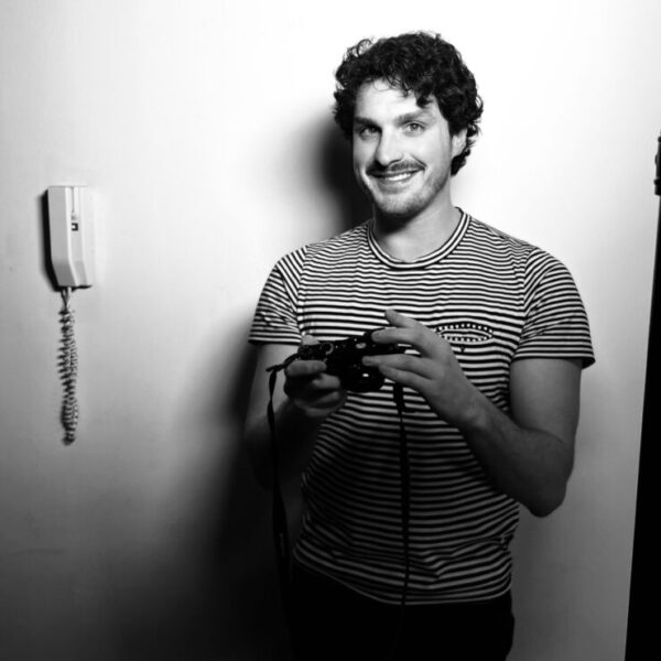 Headshot of Leo Cvitanovich in black and white holding a camera