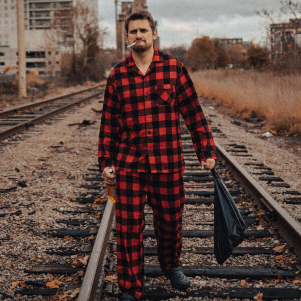 Photo of Mark McColey on train tracks in red and black pajamas