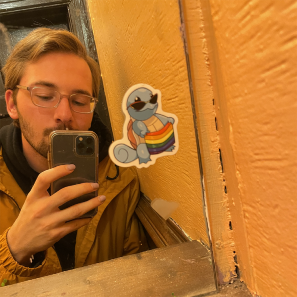 Photo of Ryan King taking a selfie in front of a mirror with a sticker on it