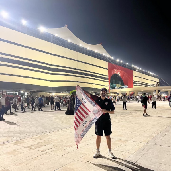 Photo of Yousef Al-Sarraf holding a USA flag outside of a stadium