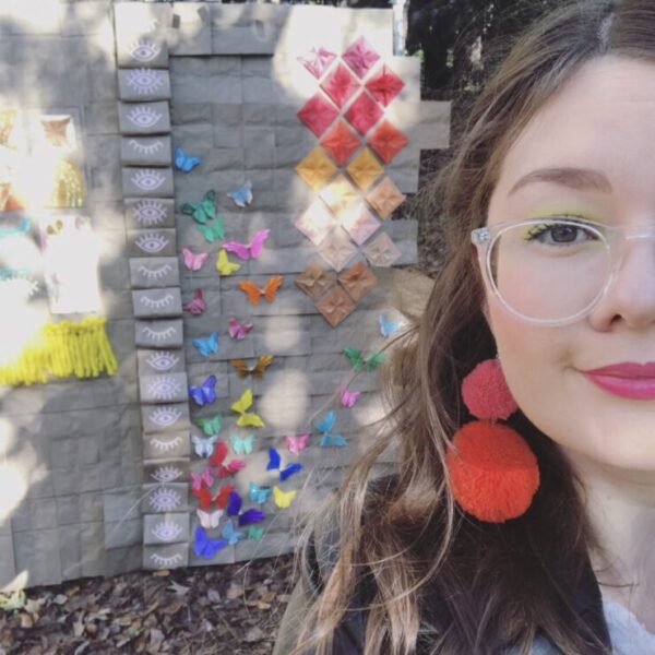 Headshot of Meaghan McFarland in front of a wall with butterflies and different colored tiles