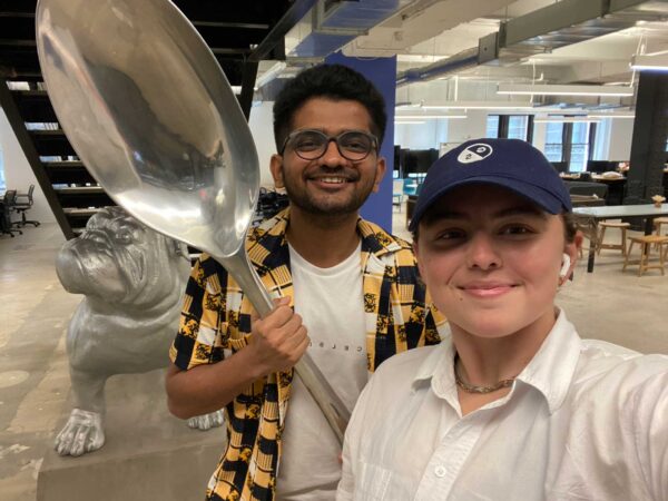 Two students pose in the office of their internship company