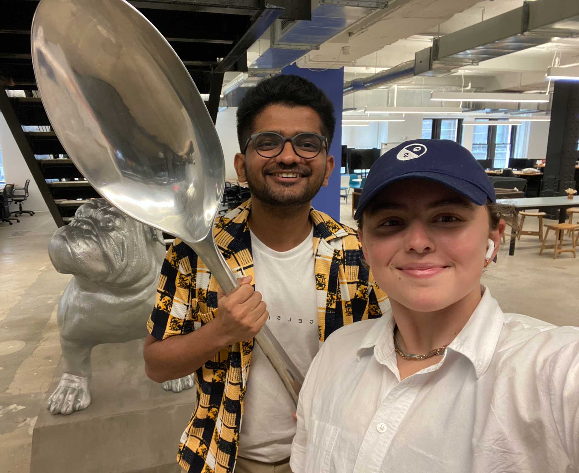 Two students pose in the office of their internship company