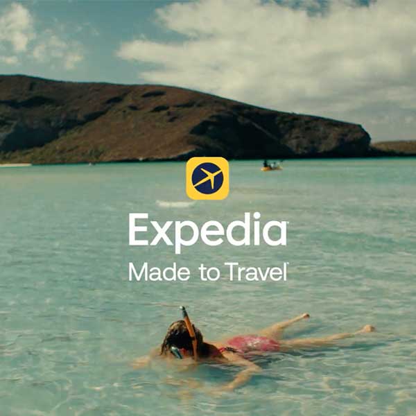 A screengrab from an Expedia commercial where a snorkler is face down in blue clear water