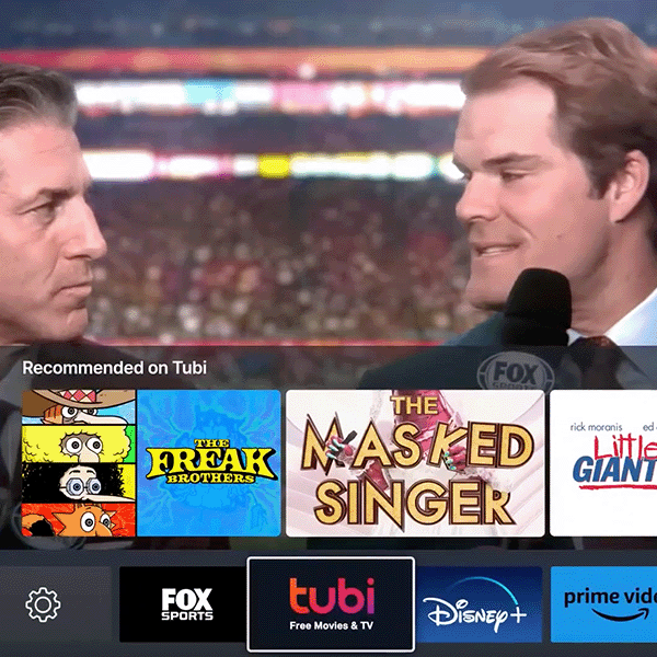 A screengrab of the Tubi commercial from the Super Bowl where two commentators are talking and the Tubi menu on the tv