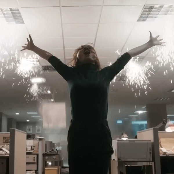 Screengrab of Zen Business commercial with a woman with her arms up in an office setting with the lights exploding behind her