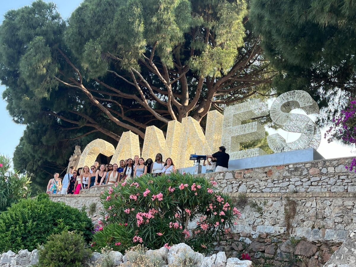 group shot with crew in front of a giant cannes sign