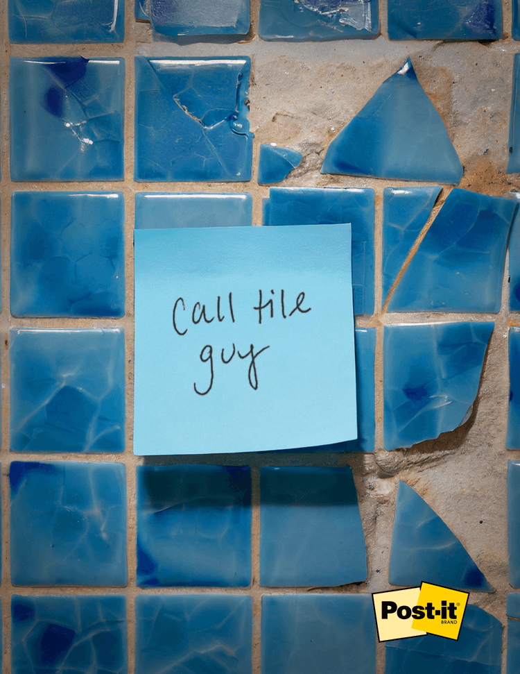a blue post it on top of broken blue tile. the post it says call tile guy
