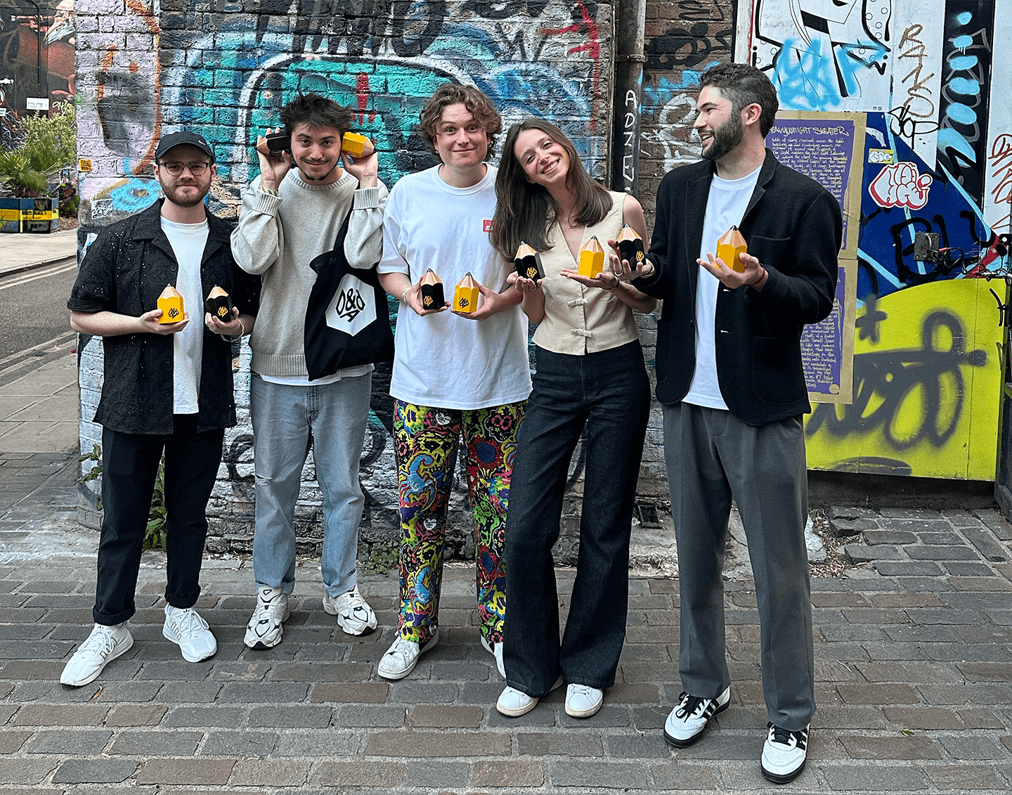 award winners standing outside the ceremony with yellow and black pencils