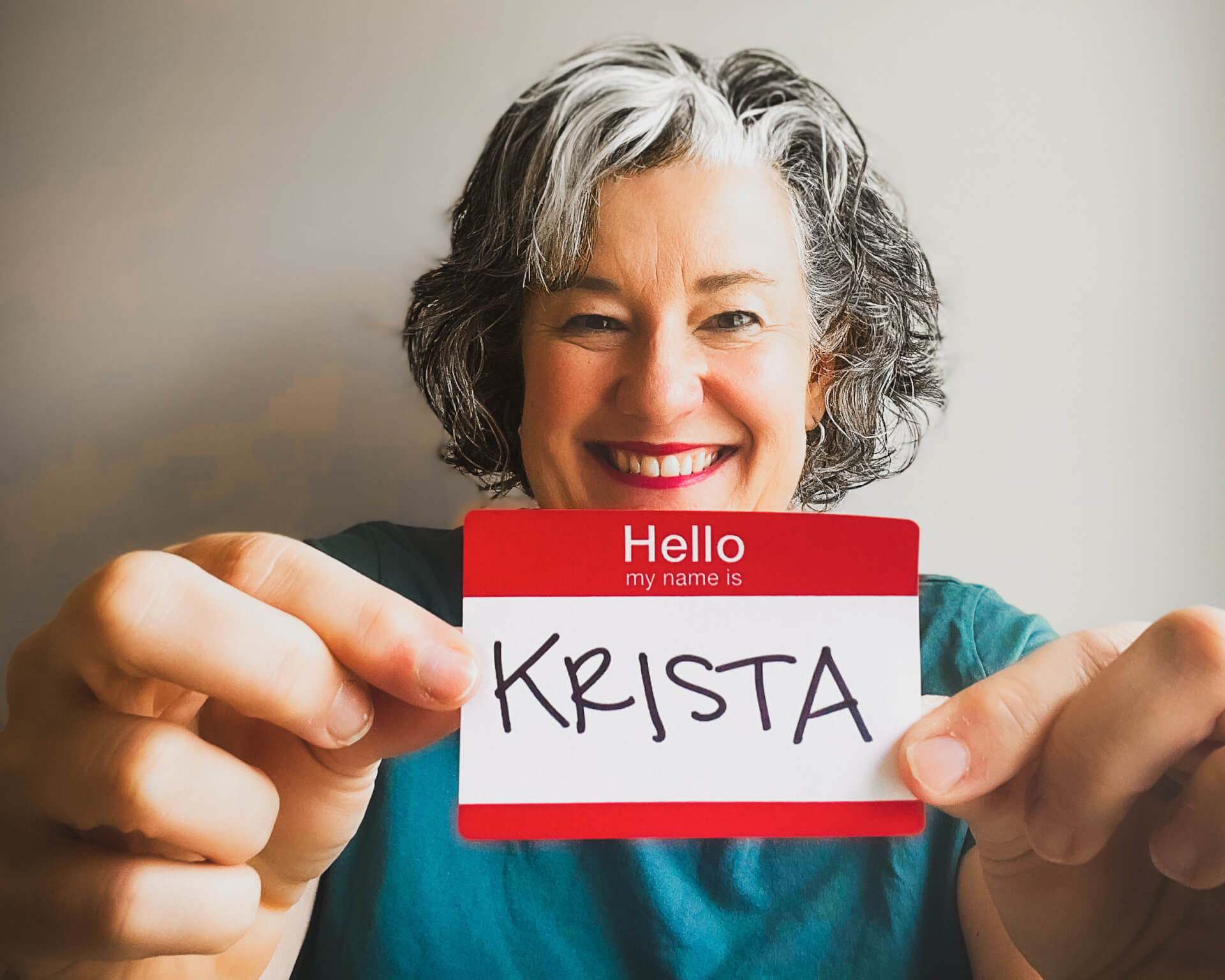 krista holding up a name tag with krista written in sharpie