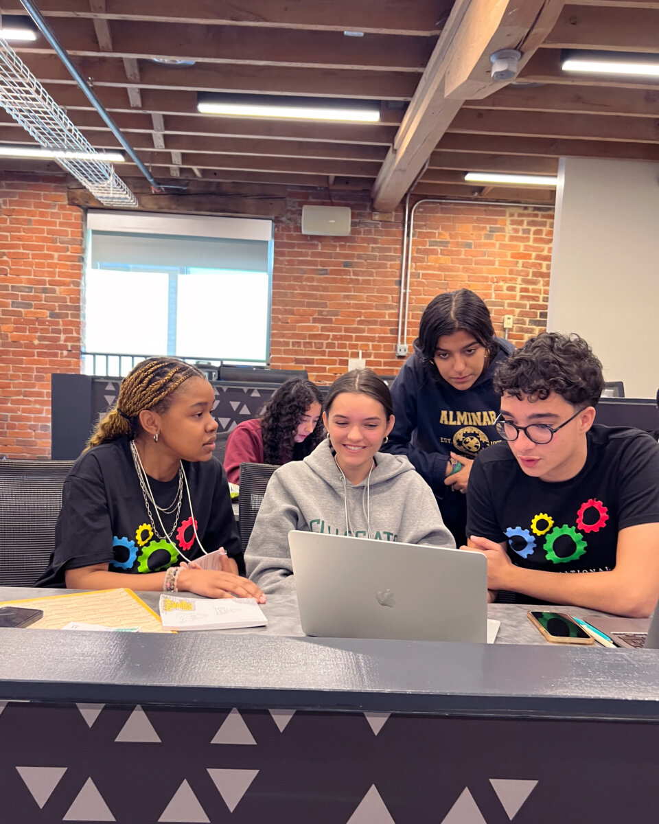 group of students looking at laptop