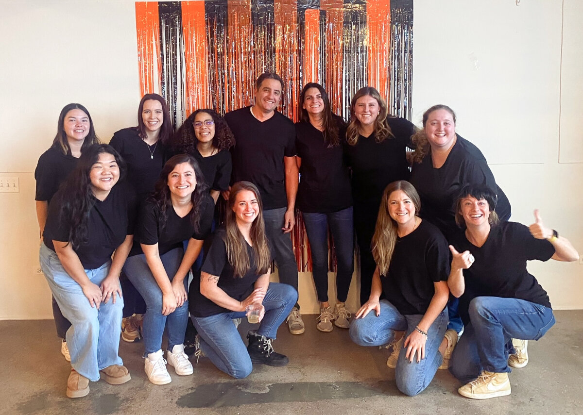 group of colleagues at halloween party wearing jeans and black t shirts