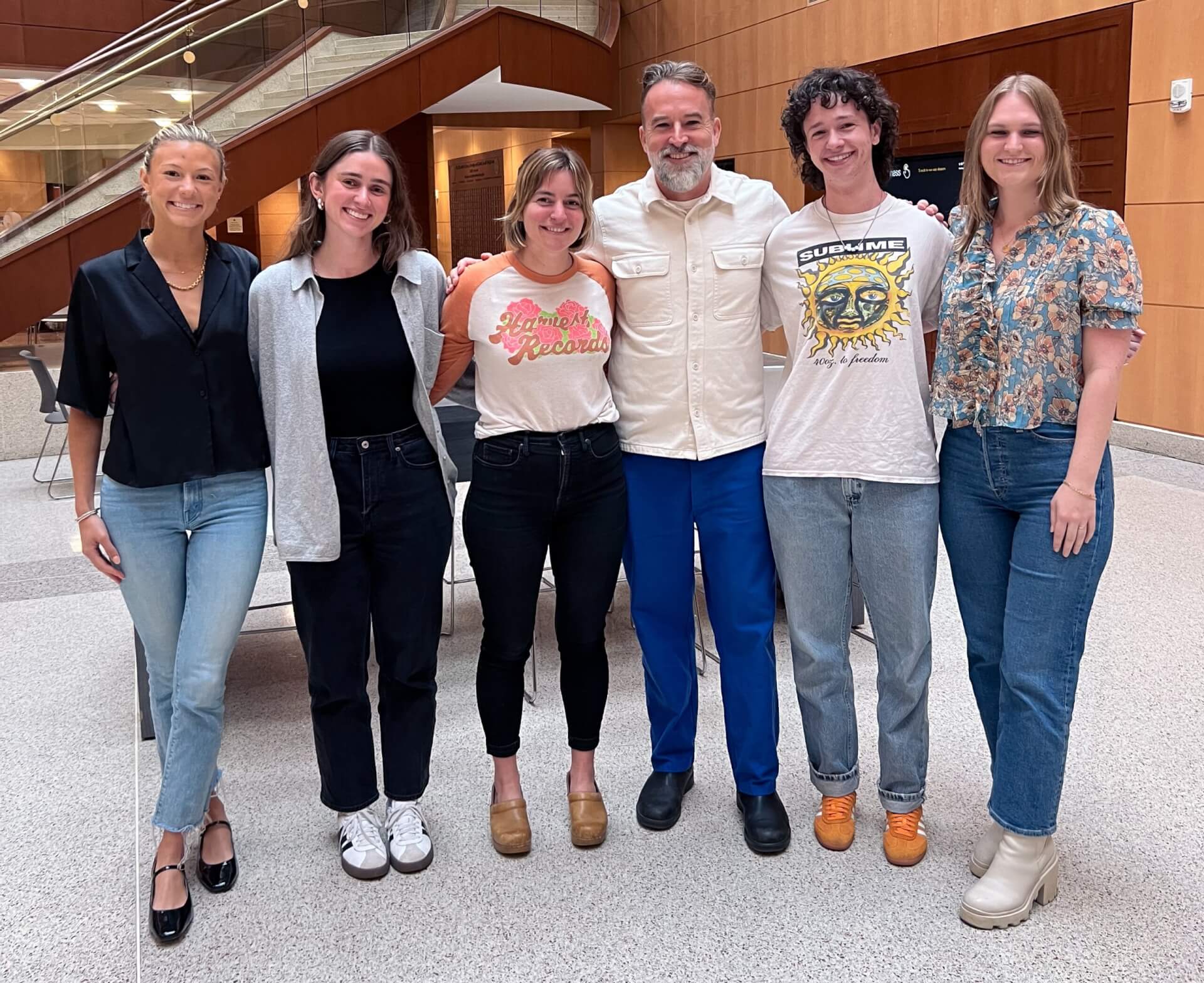 Ebenezer smiling with students following his lecture