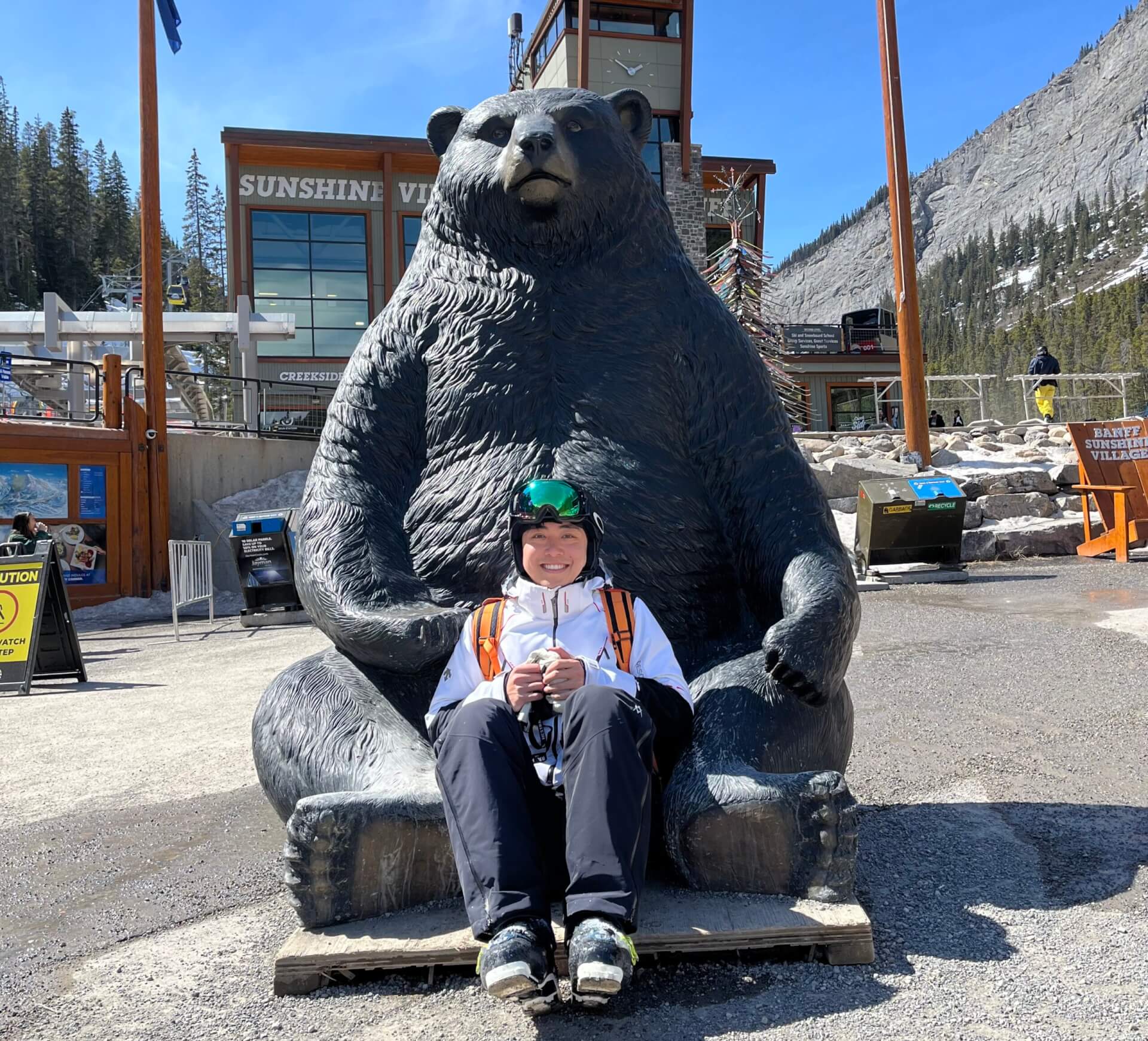 chen in snow gear in front of a bear statue